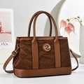 Detailed view of dark brown textured leather tote with caramel handles and gold logo - Coffee