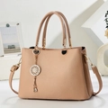 Elegant beige pebbled leather tote bag with gold circular pendant and adjustable strap - Khaki