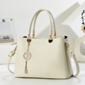 Elegant beige pebbled leather handbag with gold hardware and stylish metal charm detail - Off-white