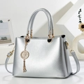 Detail of silver lychee texture handbag with golden dreamcatcher pendant and metallic finish - Silver