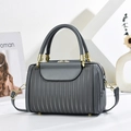 Grey striped embossed Boston bag with gold hardware and adjustable strap in modern setting - Gray