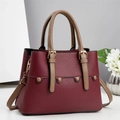 Detailaufnahme der weinroten Ledertasche mit Goldschnalle und modischen Nieten - Rot