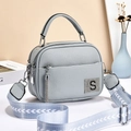 Elegant light blue lychee textured handbag with wide woven strap and silver tassel charm - Blue