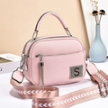 Pink faux leather bag detail with silver tassel and S-logo on light background - Pink