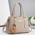 Sac à main élégant en cuir beige grainé avec détails dorés et pompon en peluche - Blanc Cassé
