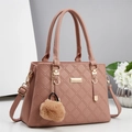 Détail d'un sac à main en cuir matelassé rose avec finitions dorées et pompon - Rose
