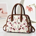Detail of a beige cherry print tote bag with brown leather trim and golden metal hardware - Off White