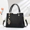 Elegante bolso negro plisado con colgante de perla y hoja dorada en base de piedra mínima - Negro
