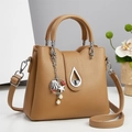 Elegant tan faux leather bucket bag with seashell pendant and metallic water-drop clasp - Camel