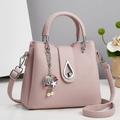 Bolso tipo cubo en cuero rosa pálido grano lichi con herrajes plateados y dije perla - Rosa Claro