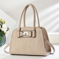 Dettaglio della borsa in pelle beige con goffratura a cuore e fibbia metallica a fiocco - Bianco Sporco