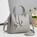 Detail of light gray lychee grain leather bucket bag with sea-themed charms and silver hardware - Light Gray