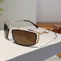 Détail de lunettes Y2K avec branches dorées ondulées et verres marron foncé en métal - Monture Dorée Verres Ambrés
