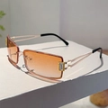 Macro detail of rimless square sunglasses with orange gradient lens and crystal accents - Gold Frame Gradient Orange Lens Gold Accessories White Rhinestone Black Foot Cover