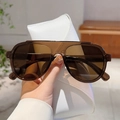 Lunettes de soleil aviateur marron avec étui en cuir blanc tenues à la main - Monture Thé Verres Thé