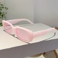 Lunettes de soleil rectangulaires roses avec verres translucides sur support épuré - Monture rose gelée verres roses