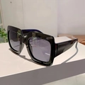 Dettaglio di occhiali da sole squadrati neri oversize con aste larghe su espositore - Montatura Nera Lenti Grigie