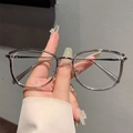 Occhiali in metallo argento a montatura sottile con grandi lenti tonde tenuti a mano - Montatura Grigio Trasparente Argento Lente Chiara
