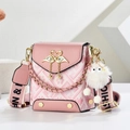 Pink mini crossbody bag with gold swan buckle and wide strap on geometric background - Pink