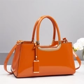 Glossy bright orange patent leather handbag with gold metal hardware and top handles - Orange