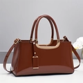 Glossy patent leather handbag in caramel brown with gold metal accents and shoulder strap - Brown