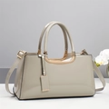 Macro view of polished light gray patent leather surface and luxury gold hardware details - Gray