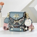 Detail of blue PU leather bag with swan buckle, pearl drop, and woven ethnic pattern - Blue