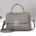 Detail of silver square buckle and pebbled grey leather texture on a crossbody bag - Gray