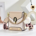 Detail of beige vintage crossbody bag with metal buckle and plush chick charm accessory - Khaki