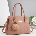 Détail du sac à main rose avec texture litchi, motif tressé et logo en métal doré - Rose