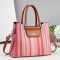 Detail der rosa gewebten Textur und braunen Ledergriffe an der Handtasche - Rosa