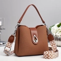 Detail of brown woven bucket bag featuring metal lock and chevron knit shoulder strap - Khaki/Earth Yellow