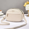 Elegante borsa a tracolla beige texture litchi con finiture dorate in un ambiente minimalista - Bianco Sporco
