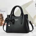 Detail of black lychee grain leather tote bag with bow and pearl pendant decoration - Black