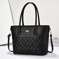 Retro black leather tote bag with quilted pattern and gold bow accent on white background - Black