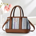 Chic woven tote bag in purple and blue with brown leather handles and gold accents - Purple