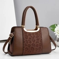 Borsa a mano in pelle marrone con pannello leopardato e dettagli dorati su sfondo neutro - caffè