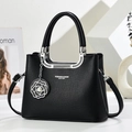 Detail of black lychee grain leather handbag with pearl camellia charm and silver hardware - Black