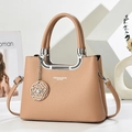 Detail of camel lychee leather bag featuring a silver U-shaped handle and floral charm - Khaki