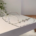 Detailaufnahme des silbernen Metallgestells mit luxuriösen Strasssteinen und Nieten - Transparentes Glas Silberner Bügel