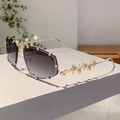 Detailansicht goldener Metallbügel und kristalbesetzter Ränder an der Sonnenbrille - Verlaufend Grau Goldener Bügel