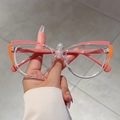 Detalle macro de montura de gafas cat-eye con bloques de color rosa y naranja unidos - Montura Rosa Naranja Transparente Patas Rosas