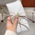 Cat eye glasses with gold metal frames and tortoiseshell accents in a handheld close-up - Tortoiseshell Gold Frame Clear Lens