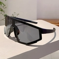 Détail de lunettes de cyclisme noir mat avec grands verres gris sur support géométrique - Monture noire verres gris