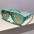 Moderne aviator zonnebril met turquoise montuur en groene glazen op een grijs voetstuk - Groen Frame / Groene Lenzen