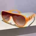 Detail of orange oversized sunglasses with brown gradient lenses and gold temple accents - Orange Frame Gradient Tea Lens