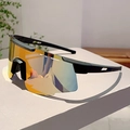 Detalle de gafas de ciclismo con patillas ventiladas y lentes de espejo naranja vibrante - Montura Negra Espejo Dorado Puntas Negras