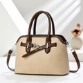 Detalle de bolso de concha en cuero beige y marrón con textura de lichi y hebillas de plata - Caqui