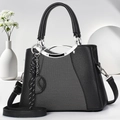 Elegante schwarze Handtasche aus strukturiertem Leder mit silbernen Beschlägen und Anhänger - Schwarz