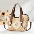 Close-up of geometric ethnic pattern woven tote with leather handles and metallic hooks - Khaki